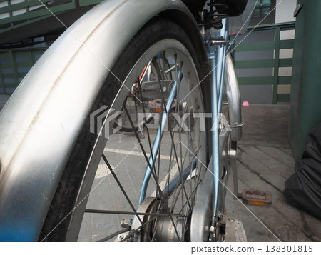 Close up bicycle wheel metal fender rear wheel urban parking area transportation silver spoke detail view Close up bicycle wheel with shiny metal fender urban parking area, silver frame and spoke Close up bicycle wheel metal fender rear wheel urban parking area transportation silver spoke detail view Close up bicycle wheel with shiny metal fender urban parking area, silver frame and spoke 138301815