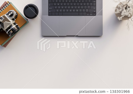 Top view close up a laptop with coffee cup and camera over books and flower vase on the white table. Top view close up a laptop with coffee cup and camera over books and flower vase on the white table. 138301966