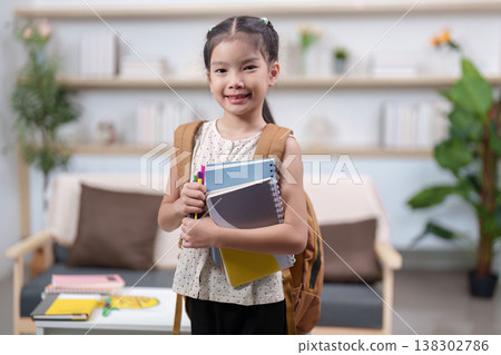 Smiling student holding school supplies and backpack Smiling student holding school supplies and backpack 138302786