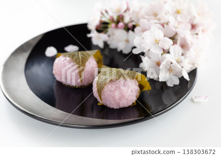 Sakura mochi and Somei Yoshino cherry blossoms served in a black lacquered bowl. 138303672