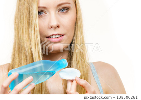 Woman cleaning her face skin with cotton pad Woman cleaning her face skin with cotton pad 138306261