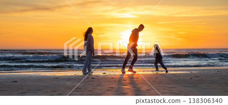 Family enjoying beach walk during golden sunset Family enjoying beach walk during golden sunset 138306340