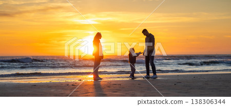 Family enjoying beautiful sunset at beach together 138306344