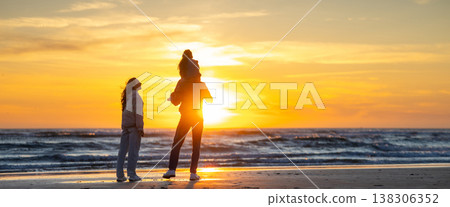 Family enjoying togetherness watching colorful ocean sunset 138306352