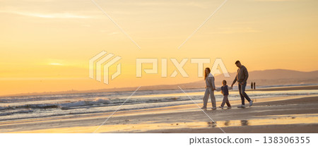 Family walking on beach at golden hour during sunset 138306355