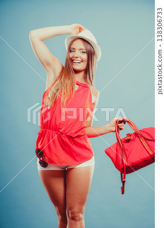 Woman in hat and red shirt with handbag sunglasses 138306733