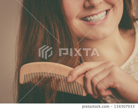 Happy woman brushing her hair Happy woman brushing her hair 138307033