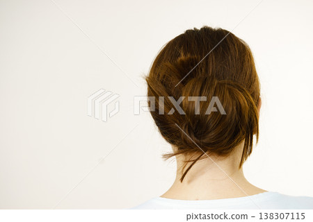 Girl with brown long hair tied in bun Girl with brown long hair tied in bun 138307115