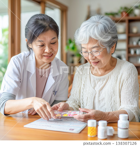 一位老婦人正在接受護理人員關於用藥的指導。 一位老婦人正在接受護理人員關於用藥的指導。 138307126