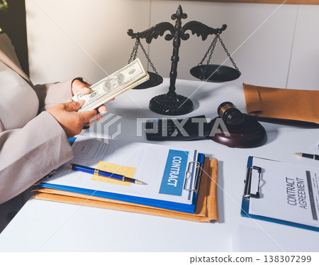 Judge gavel with Justice lawyers having team meeting at law firm in background. Notary with client in office 138307299
