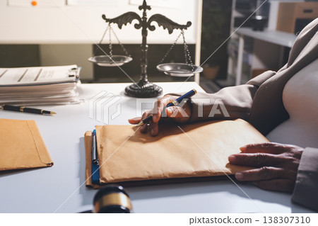 Judge gavel with Justice lawyers having team meeting at law firm in background. Notary with client in office Judge gavel with Justice lawyers having team meeting at law firm in background. Notary with client in office 138307310
