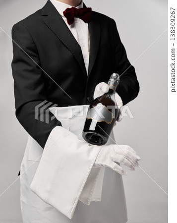 Close up of waiter hands holding champagne bottle in elegant service pose. Close up of waiter hands holding champagne bottle in elegant service pose. 138309267