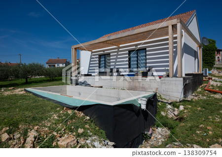 Modular modern minimalistic house under construction with unfinished pool and energy efficient solar features Modular modern minimalistic house under construction with unfinished pool and energy efficient solar features 138309754
