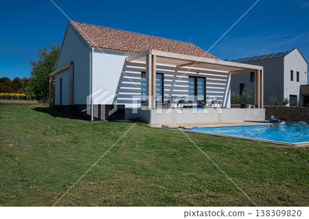 Modern modular minimalistic house with pergola, swimming pool and solar panels emphasizing energy efficiency Modern modular minimalistic house with pergola, swimming pool and solar panels emphasizing energy efficiency 138309820