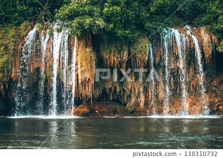 Sai Yok Yai waterfall in Thailand flowing into river surrounded by lush tropical jungle in national park, Wide scenic cascade with rich textures and natural beauty, travel and tranquility Sai Yok Yai waterfall in Thailand flowing into river surrounded by lush tropical jungle in national park, Wide scenic cascade with rich textures and natural beauty, travel and tranquility 138310732