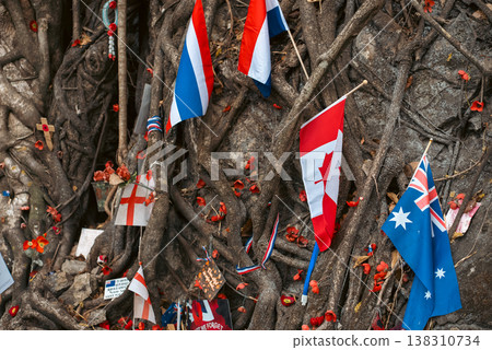 War memorial at Hellfire Pass Thailand with flags and tribute symbols in nature, Remembrance site with international flag and flowers honoring fallen soldiers in historic location 138310734