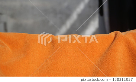 Orange towel on the wall, closeup of photo with soft focus. Orange towel on the wall, closeup of photo with soft focus. 138311037