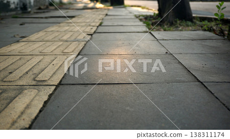 Paving stone walkway in the park at sunset time. Empty floor in perspective view for texture background. Paving stone walkway in the park at sunset time. Empty floor in perspective view for texture background. 138311174