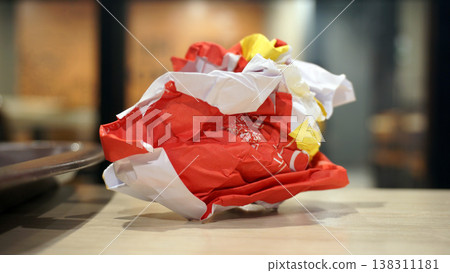 Crumpled red paper on table in coffee shop blur background with bokeh. Crumpled red paper on table in coffee shop blur background with bokeh. 138311181