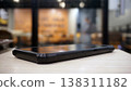 Smartphone on wooden table in coffee shop. Blurred background. 138311182
