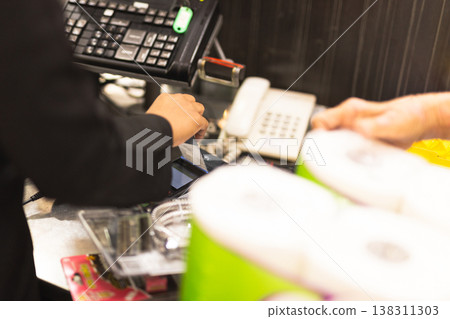 Customer inserting a credit card into payment terminal at supermarket checkout. Customer inserting a credit card into payment terminal at supermarket checkout. 138311303