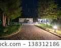 Modern modular house at night with rainlit driveway, car and garden lights showcasing low energy design 138312186