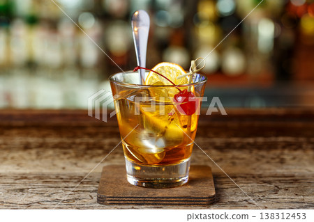 Old-fashioned cocktail garnished with orange Old-fashioned cocktail garnished with orange 138312453