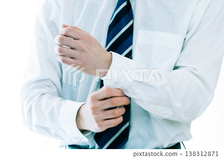 一位商人正在繫上袖扣。 一位商人正在繫上袖扣。 138312871