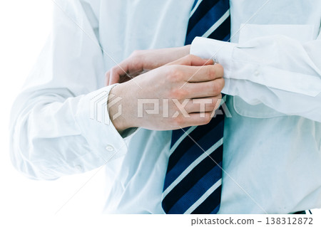 一位商人正在繫上袖扣。 一位商人正在繫上袖扣。 138312872