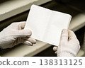 Hands in white gloves holding an open blank notebook for notes or planning 138313125