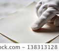 Hand wearing white glove pointing at blank paper, close-up shot 138313128