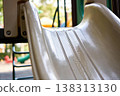 Close-up view of a wet playground slide, showing textured surface and reflections 138313130
