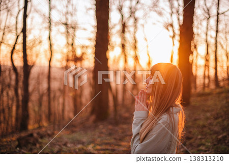 Woman Practicing Mindfulness Meditation in Forest at Sunset 138313210