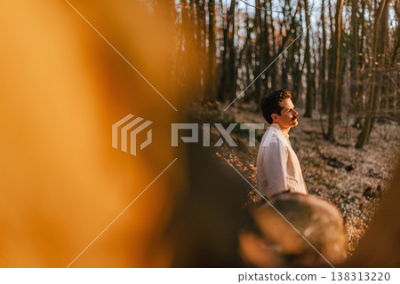 Young Man in Sunlit Forest Reflecting on Mental Health 138313220