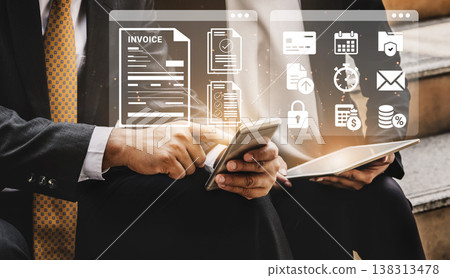 Business Professionals Using Modern Technology to Manage Invoices and Digital Tasks with Mobile Devices and Touchscreens Ledger Business Professionals Using Modern Technology to Manage Invoices and Digital Tasks with Mobile Devices and Touchscreens Ledger 138313478
