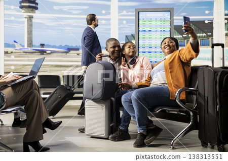 African american parents and girl smiling for photos before boarding flight, family taking pictures and being excited about their vacation abroad. Bonding time in busy airport terminal. 138313551
