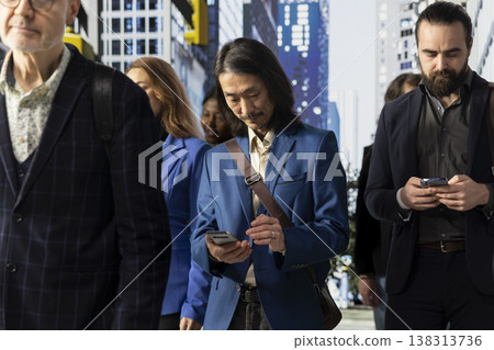 Multiethnic crowd of people walking outdoors in the business district highlights multicultural activity, man and woman pedestrians preoccupied with their routine. Dynamic urban life. Multiethnic crowd of people walking outdoors in the business district highlights multicultural activity, man and woman pedestrians preoccupied with their routine. Dynamic urban life. 138313736