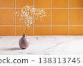 Orange ceramic tiles and a marble countertop with a bouquet of gypsophila. 138313745