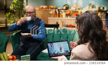 Elderly couple sitting during online telemedicine consultation with physician, asking about correct dosage of medicine. Doctor provides medical advice and wellness recommendations via video call. Elderly couple sitting during online telemedicine consultation with physician, asking about correct dosage of medicine. Doctor provides medical advice and wellness recommendations via video call. 138314564