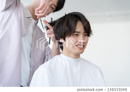 一位年輕男子在理髮店理髮。 138315049