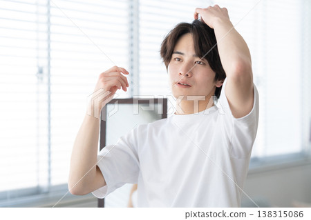 A young man doing his skincare routine by the window. 138315086