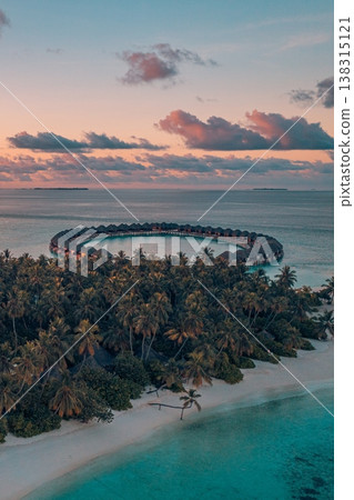 Amazing sunset Maldives resort island. Luxury travel landscape, water villas, palm trees, relaxing colorful sky, ocean water reflections Amazing sunset Maldives resort island. Luxury travel landscape, water villas, palm trees, relaxing colorful sky, ocean water reflections 138315121