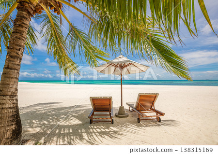 Sunny tropical beach with couple chairs, umbrella, palm trees, and ocean view, relaxing vacation tropical island travel landscape Sunny tropical beach with couple chairs, umbrella, palm trees, and ocean view, relaxing vacation tropical island travel landscape 138315169