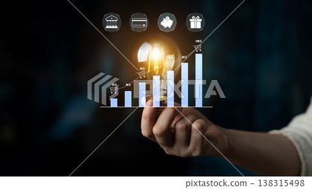 Hand Holding Light Bulb with Bar Graphs and Icons Representing Growth, Innovation, and Business Strategies in Modern Economy Quark 138315498