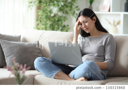 Worried asian woman complaining about online content 138315668