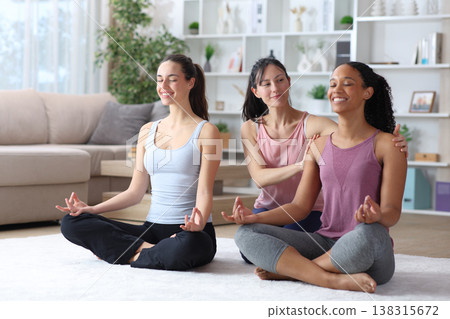 Three diverse happy women learning yoga at home Three diverse happy women learning yoga at home 138315672
