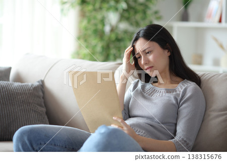 Worried asian woman reading document from folder Worried asian woman reading document from folder 138315676