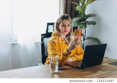 Woman recording herself on smartphone at home office showing personal branding and authentic solo content creation in remote lifestyle 138315687