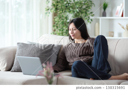 Asian woman relaxing using laptop at home 138315691