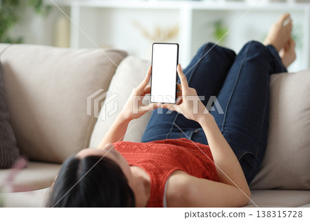 Woman showing and using phone screen at home 138315728
